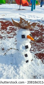 Happy Snowman With Carrot Nose And With A Big Leaf Hat