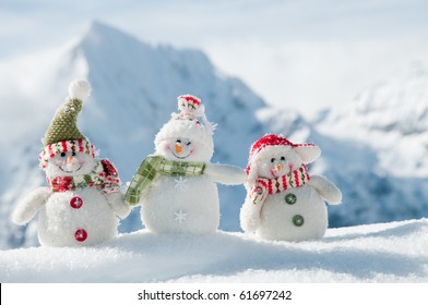 Happy snowmans in mountains (copy space)
