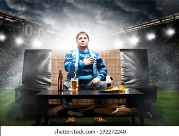 Happy Soccer Or Football Fan With Hand On Heart On Sofa At Stadium