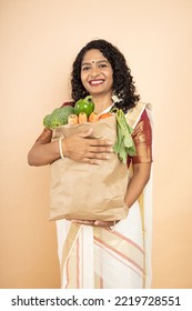 Happy South Indian Woman Hold Grocery Paper Bags With Food Isolated On Beige Background. Studio Shot.