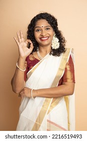 Happy South indian woman wearing traditional saree doing ok sign with fingers, smiling friendly gesturing excellent symbol. - Shutterstock ID 2216519493