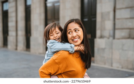 Happy southeast Asian mother with her daughter having fun in the city center - Lovely family outdoor - Powered by Shutterstock