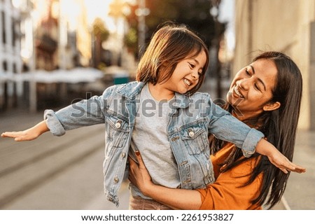 Happy southeast Asian mother with her daughter having fun in the city center - Lovely family outdoor 