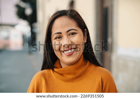 Happy southeast Asian woman having fun smiling in front of camera in the city center