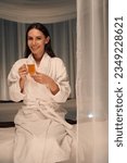 Happy spa client posing for camera with herbal beverage