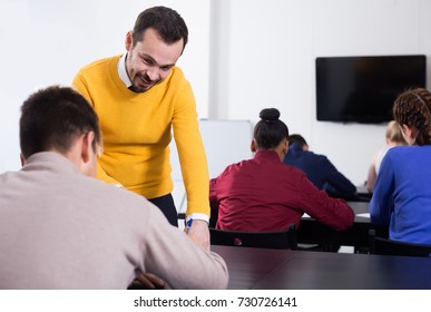 Happy Spanish  Male Teacher Clearing Up Complicated Issue To Pupil During Exam In Class