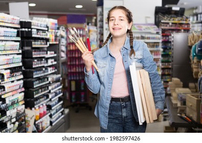 happy spanish teen girl holding supplies for painting in hands in art department. - Powered by Shutterstock