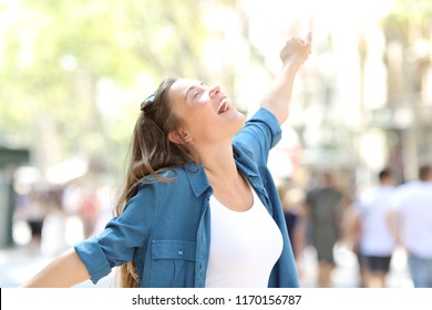 Happy spontaneus woman stretching arms celebrating success in the street