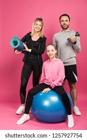 Happy Sportive Family With Fit Ball, Fitness Mat And Dumbbell Isolated On Pink