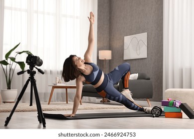 Happy sports blogger recording fitness lesson with camera at home - Powered by Shutterstock