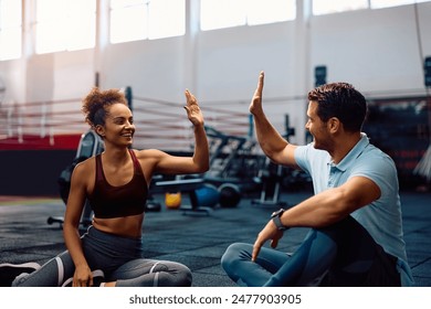 Happy sportswoman giving high-five to her fitness instructor while exercising in health club. Copy space. - Powered by Shutterstock