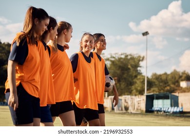 Happy sportswoman talking to her teammates while walking after soccer training on a stadium.  - Powered by Shutterstock