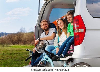 Happy Sporty Family Sitting In The Car Boot