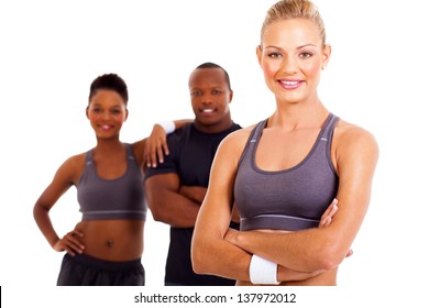 Happy Sporty Woman With Arms Folded And Gym Members On Background