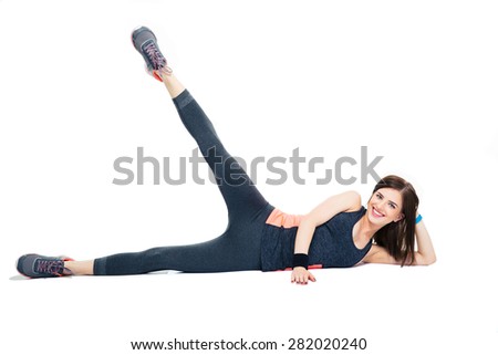 Happy sporty woman doing stretching exercise isolated on a white backgorund. Looking at camera