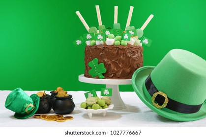 Happy St Patrick's Day, March 17, green and white party table with showstopper chocolate cake decorated with candy, cookies and shamrock flags, with lens flare. - Powered by Shutterstock