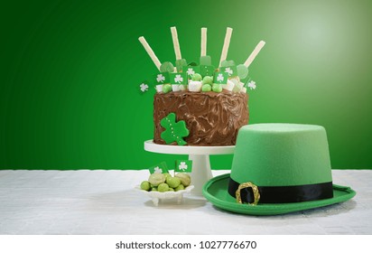 Happy St Patrick's Day, March 17, green and white party table with showstopper chocolate cake decorated with candy, cookies and shamrock flags, with lens flare. - Powered by Shutterstock