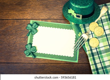 Happy St. Patricks Day Menu Or Invite Card With Shamrocks, Hat, Lucky Coins, Napkins And Fork From Top Down View With Blank Room Or Space For Copy, Text, Your Words. A Horizontal With Instagram Filter