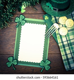 Happy St. Patricks Day Menu Or Invite Card With Shamrocks, Hat, Lucky Coins, Napkins And Fork From Top Down View With Blank Room Or Space For Copy, Text, Your Words. A Square With Dark Instagram Tone
