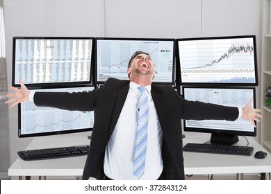 Happy Stock Broker Laughing While Standing With Arms Outstretched In Office