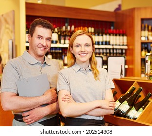 Happy Store Manager And Smiling Saleswoman In Wine Shop