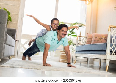 Happy Strong Father And Little Daughter Enjoying Funny Activities In Living Room.