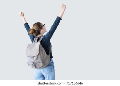 Happy student with arms raised on air - Shutterstock ID 717156646