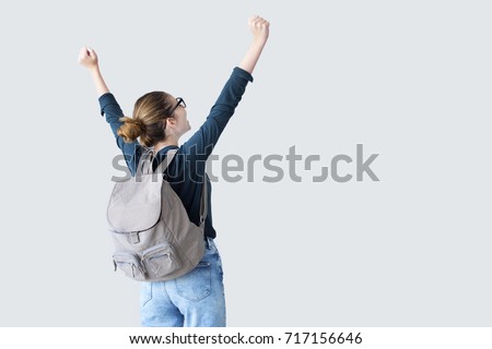 Happy student with arms raised on air