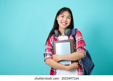 Happy Student. Cheerful Asian Girl Smiling To Camera Standing With Backpack In Studio Over Blue Background. Back to school concept.