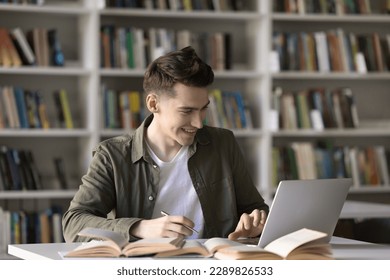 Happy student guy, teenage schoolboy prepare assignment, learn theory, studying in library using laptop. Generation Z gain new knowledge using modern wireless tech and internet resources. Education - Powered by Shutterstock