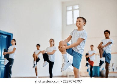 Happy student and his classmates practicing on PE class at school gym. - Powered by Shutterstock