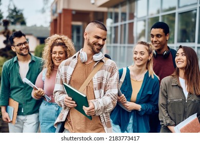 Happy student and his university friends going to a lecture at campus. - Shutterstock ID 2183773417