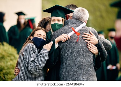 Happy Student Hugs With Her Supportive Family On Graduation Day During COVID-19 Pandemic.