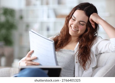 Happy student is learning reading notes at home reading notes