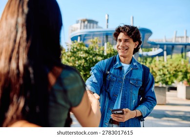 Happy student smiling while shaking hand with a person on campus
