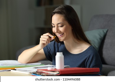 Happy Student Studying Late Hours In The Night Taking A Vitamin Pill At Home