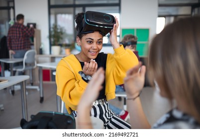 Happy Student Wearing Virtual Reality Goggles At School In Computer Science Class, Playing With Her Schoolmate.