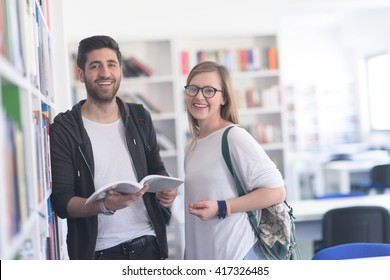 Happy Students Couple In School  Library Have Discussion About Book