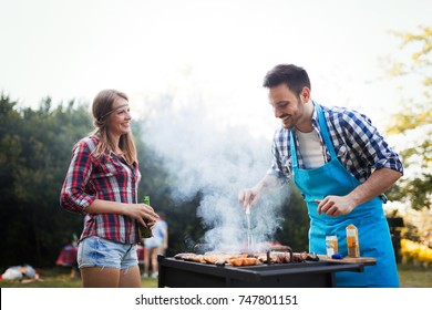 Happy students having barbecue on summer day
