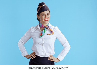 happy stylish flight attendant woman against blue background in uniform.