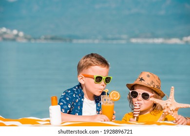 Happy Stylish Little Boy And Toddler Girl Drinking Orange Juice And Eating Ice Cream On Tropical Beach Resort. Family With Kids Luxury Travel. Fashionable Child In Sunglasses.