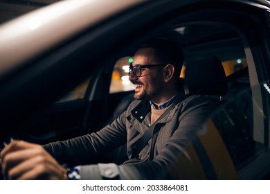 Happy Stylish Man Sitting In His Car Driving At Night With A Big Smile On His Face