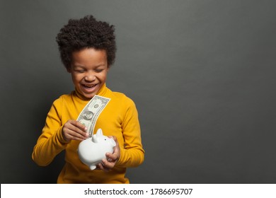 Happy Successful African American Child With Money Box And One Us Dollar On Blackboard Background