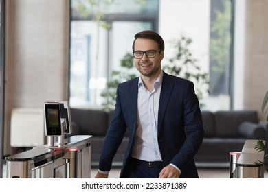 Happy successful ambitious office employee, businessman or entrepreneur smile look at camera while enters workspace, approaching entrance, going through security gates doorway, starting working day - Powered by Shutterstock