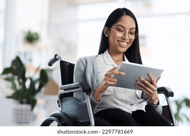 Happy and successful. an attractive young businesswoman in a wheelchair using her tablet in the office. - Powered by Shutterstock