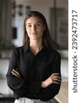 Happy successful beautiful business leader woman vertical portrait. Confident young professional, entrepreneur, company owner girl posing for head shot with arms crossed, looking at camera