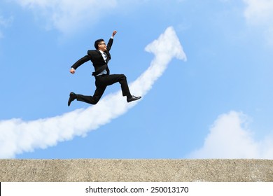 happy successful business man jump and run with arrow cloud and blue sky background, asian male