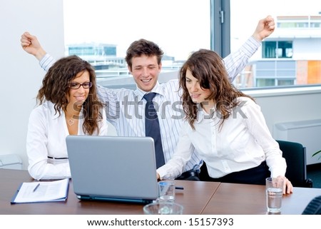Happy successful business people sitting on meeting at office, working on laptop computer, smiling.