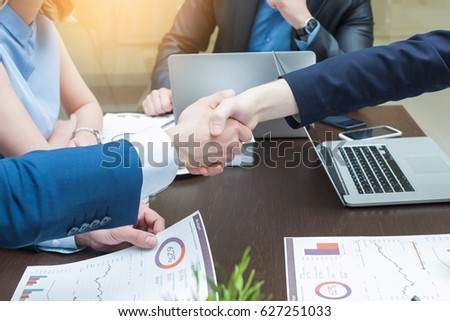 Happy successful Businesspeople shaking hands in board room