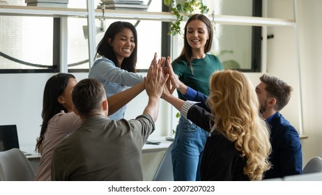 Happy successful diverse team giving high five, sitting in circle on meeting, discussing business project success, work result, teamwork achieve. Group making unity gesture, expressing high motivation - Powered by Shutterstock